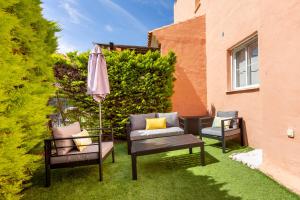 a patio with two chairs and a table and an umbrella at Bajo con jardín privado # Largas estancias # Playa 8min # Chill out in Vera