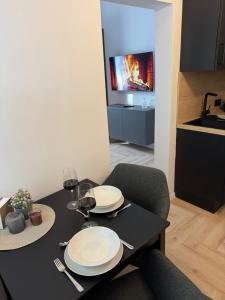a dining room table with two white plates and a television at DLG-STAYS Iserlohn in Iserlohn