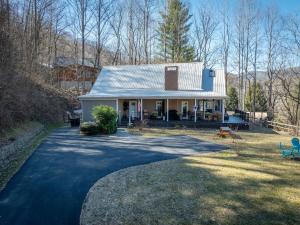 a house with a blue roof and a driveway at Halfback Ridge-heart of Maggie Valley-hot tub-fenced pet area-gazebo-views in Maggie Valley