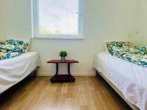 a room with two beds and a table with a window at Cozy 4 room house in Eslöv in Eslöv