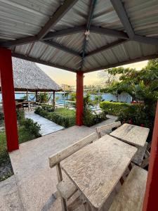 a picnic table under a pavilion with a view of the ocean at Lomeli’s Home, 5 minutos del Tunco in La Libertad +50 photos