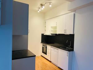 an empty kitchen with white cabinets and a sink at Cozy 4 room house in Eslöv in Eslöv