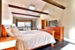 a bedroom with a bed and a tv on a dresser at Beartopia- Hot Tub, Views, 2 Primary Suites! in Killington