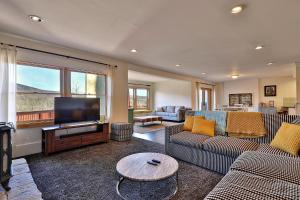 a living room with couches and a flat screen tv at Beartopia- Hot Tub, Views, 2 Primary Suites! in Killington
