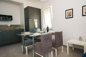 a kitchen with a table with chairs and a bottle of wine at Apartments More in Kožino