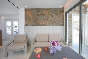 a waiting room with two chairs and flowers on a table at Fabrikas in Mýkonos City