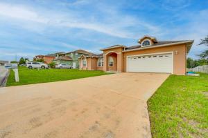 a house with a driveway in front of it at Private Pool and Lanai Family Home in Haines City! in Haines City