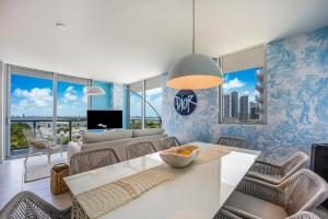 un salon avec une table et des chaises blanches dans l'établissement Nomada Destination Residences - Quadro, à Miami
