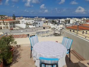 een tafel en stoelen op een balkon met uitzicht op een stad bij Rethymno Blue in Rethimnon