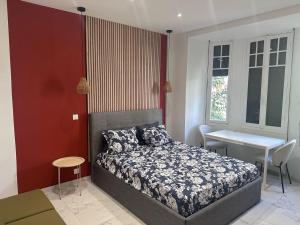 a bedroom with a bed and a table and a desk at Beautiful and super central in Nice