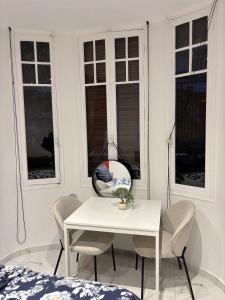 a white table and chairs in a room with windows at Beautiful and super central in Nice +14 photos