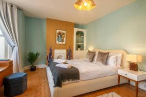 マーゲイトにあるCosy Margate Getaway, Sleeps 5 By Adlivの大きなベッドと暖炉のある寝室