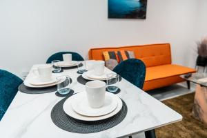 セールにあるSale 2-Bedroom Apt - Sleeps 5 - Free Parkingのダイニングルームテーブル(皿、カップ、椅子付)