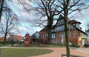 a large brick building with a playground in front of it at Meridian in Gehrden