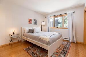 a white bedroom with a bed and a window at Charming 2 bedroom 2 bath On-Mountain in 10 Min in Avon