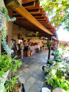 an outdoor patio with a wooden roof and plants at O Candeeiro - Hostel Acampamento in Arcoverde +14 photos