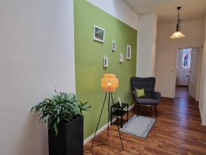 a living room with a green wall and a chair at Gästeliebling, Apartment Piepmäker mit Parkplatz und Terrasse, Bahnhof fußläufig in Goslar