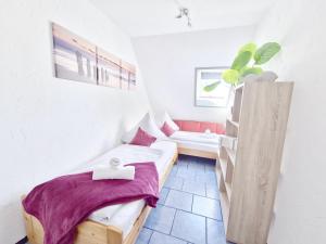 une petite chambre avec deux lits et un canapé dans l'établissement Dünenlounge Dornumersiel, à Dornum