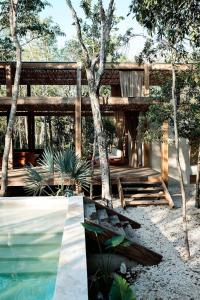 a wooden pavilion with a bench and a swimming pool at Casa Xul in Tulum