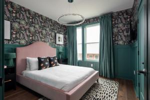 a bedroom with a pink bed and floral wallpaper at Ivy at The Lucy by Stay Local Nashville in Nashville