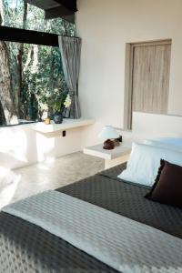 a bedroom with a bed and a large window at Casa Xul in Tulum