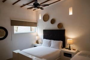 a bedroom with a bed and a ceiling fan at Posada & Spa La Ardileña en Morrocoy in La Luisa