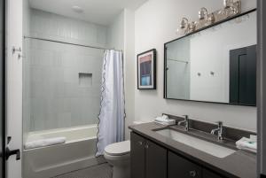 a bathroom with a sink and a toilet and a mirror at Ivy at The Lucy by Stay Local Nashville in Nashville