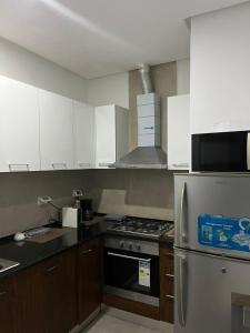 a kitchen with white cabinets and a stainless steel refrigerator at Le Chill Out in La Marsa