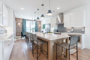 a kitchen with a large island with bar stools at Jocelyn at The Lucy by Stay Local Nashville in Nashville