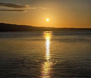 un barco en medio del agua al atardecer en App VITO, en Senj