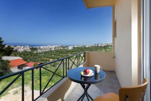 Una habitación con una mesa con un pastel en un balcón. en Kds Overlooking Chania, en La Canea
