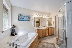 La salle de bains est pourvue d'une baignoire, de 2 lavabos et d'une douche. dans l'établissement Star of the Mountain Yosemite Home, à Groveland