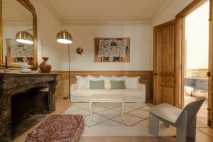 un soggiorno con un divano bianco e un camino di Maison Esme - Charm & Authenticity a Salles-d'Aude