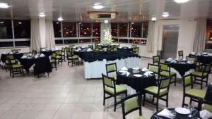 a banquet hall with tables and chairs in a room at Hotel Vollare in Osasco