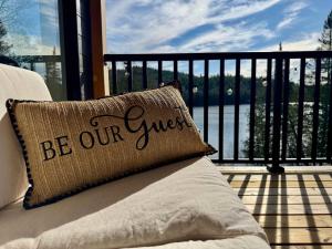 a pillow that says be our guest on a balcony at Skyville in Cayamant