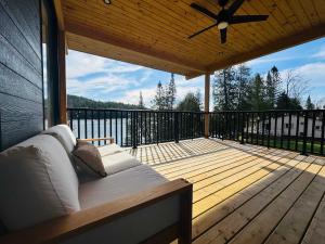 a porch with a couch on a wooden deck at Skyville in Cayamant