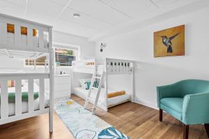 a bedroom with two bunk beds and a blue chair at Keppel Cove in Saugatuck