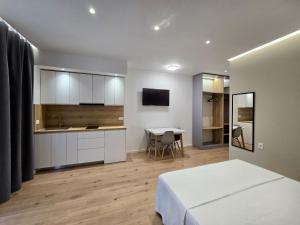 a bedroom with a bed and a kitchen and a table at David's Studio Stays in Vlorë