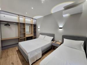 two beds in a small room with two beds sidx sidx sidx at David's Studio Stays in Vlorë