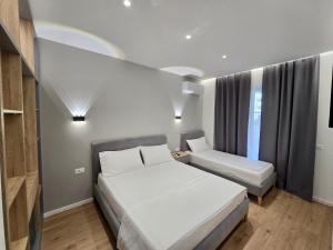 a small bedroom with a bed and a chair at David's Studio Stays in Vlorë