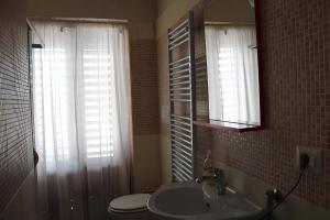 a bathroom with a sink and a toilet and a mirror at La bella vista in Conocchia +9 photos