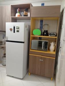 a kitchen with a white refrigerator and a microwave at Ap Família Shopping Riomar e Praia in Aracaju