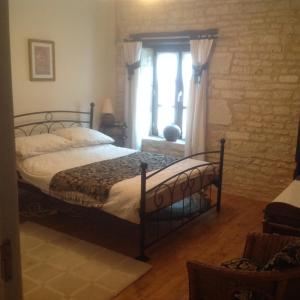 Tusson的住宿－Le Grenier 1 Rue Verte Tusson 16140 France，一间卧室设有一张床和一个窗口