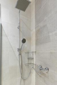 una ducha con cabezal de ducha en un baño en Aiolos Elegant retro suite in GLYFADA centre, en Atenas 43 fotos más