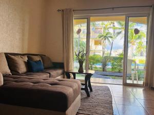 a living room with a couch and a sliding glass door at Beach Bliss in our Bungalow in Flic-en-Flac