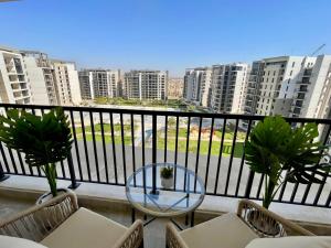 - un balcon avec une table, des chaises et des bâtiments dans l'établissement ZED Park Skyline - 3BR - Huge Terrace & City View, à Sheikh Zayed