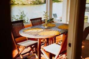 a wooden table with chairs around it with a view of the water at Shangri-La Boutique Bed & Breakfast in West Bay