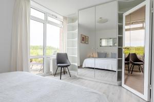 a bedroom with a bed and a glass wall at Dünennest in Südstrand