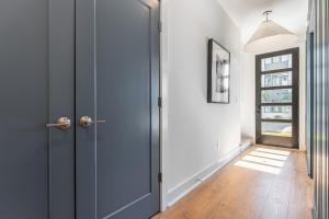 a hallway with a blue door and a window at Mira at The Lucy by Stay Local Nashville in Nashville