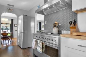 a kitchen with a stainless steel stove and a table at MIDCENTURY MANOR-Hot Tub & 5 Blocks to Town Center in Paso Robles